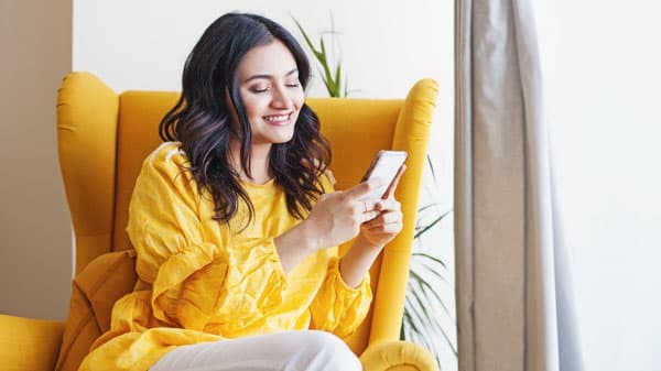 Young woman using her mobile phone for online shopping with her online gift card 