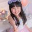 Young girl smiling at her birthday party with cake and decorations in the background
